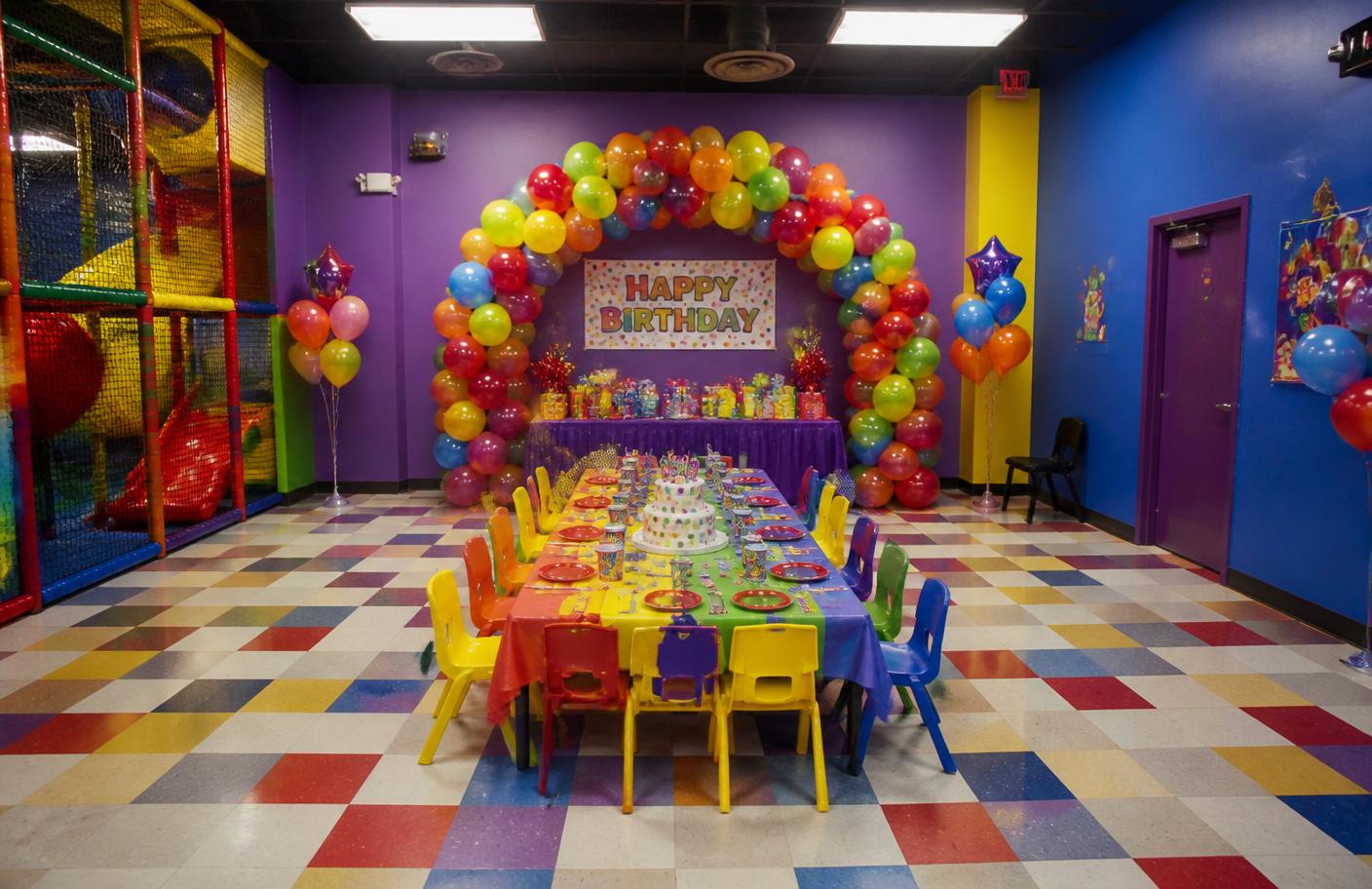 Decorated party room with balloons and a birthday table set for kids